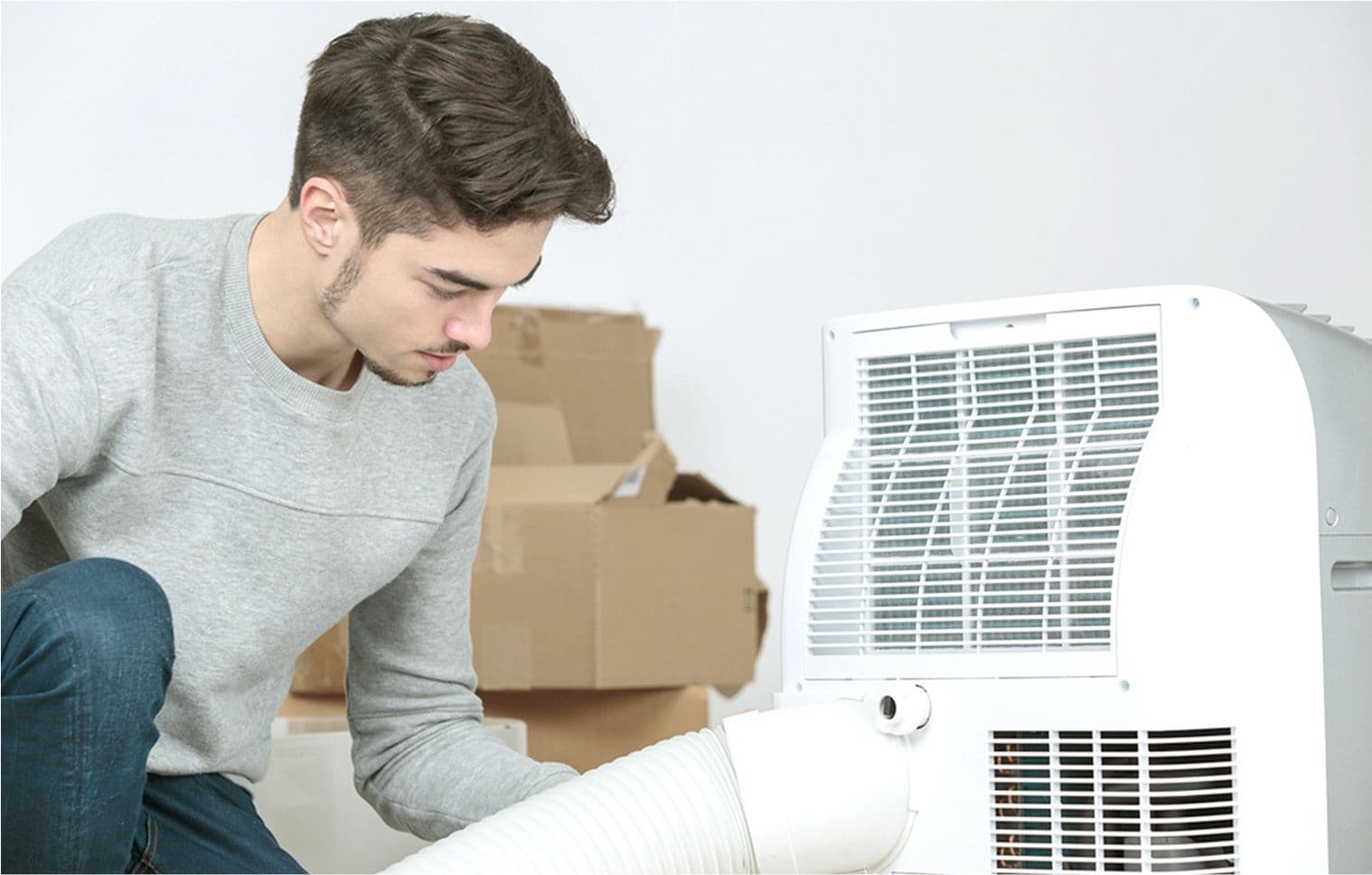 A man comfortably working with the exhaust hose of his portable aircon