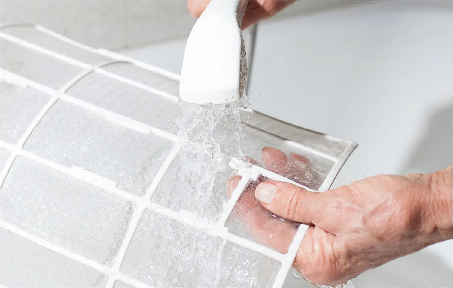 A homeowner prioritizing aircon cleaning by washing their aircon filters