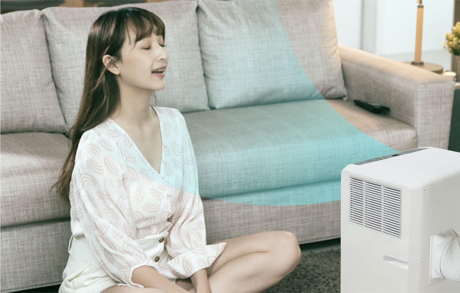 A refreshed woman being directly cooled thanks to her Carrier Philippines portable aircon