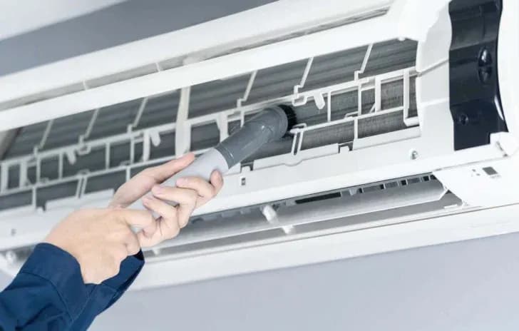 A professional cleaner cleaning the filters of a split type aircon